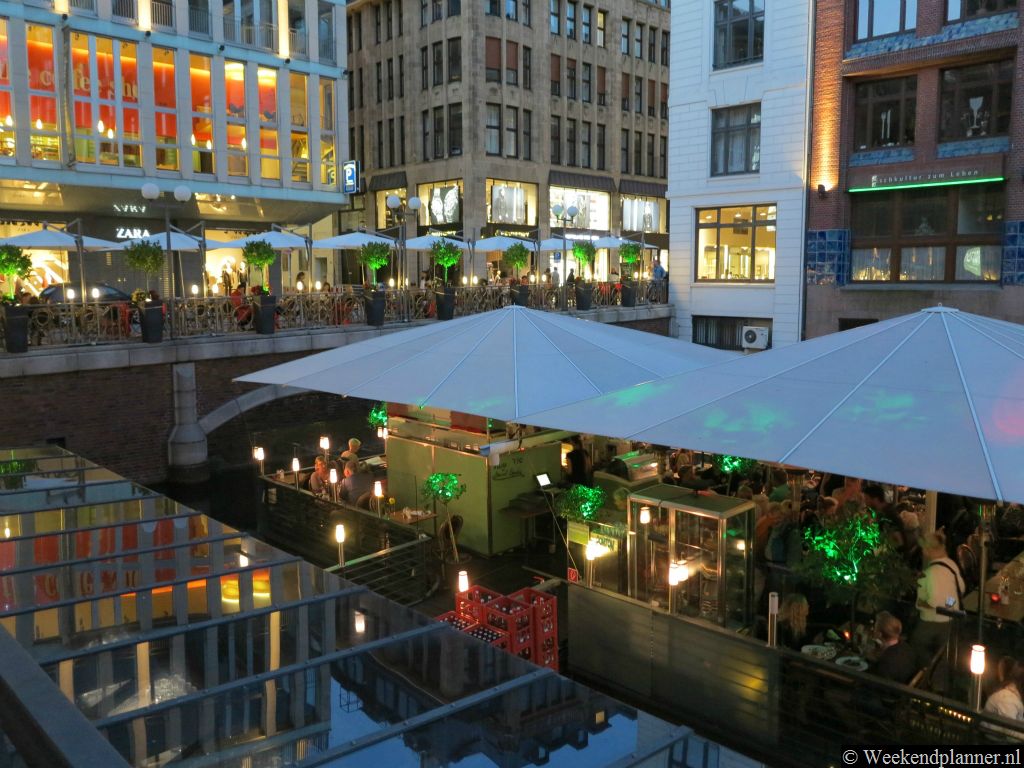 De restaurants achter het warenhuis Alsterhuis in de binnenstad van Hamburg worden in de avond romantisch verlicht. Tip: Ga eens in de buurt picknicken.